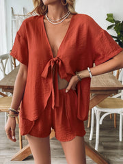 Terracotta linen lounge set with tie-front top and scalloped shorts.
