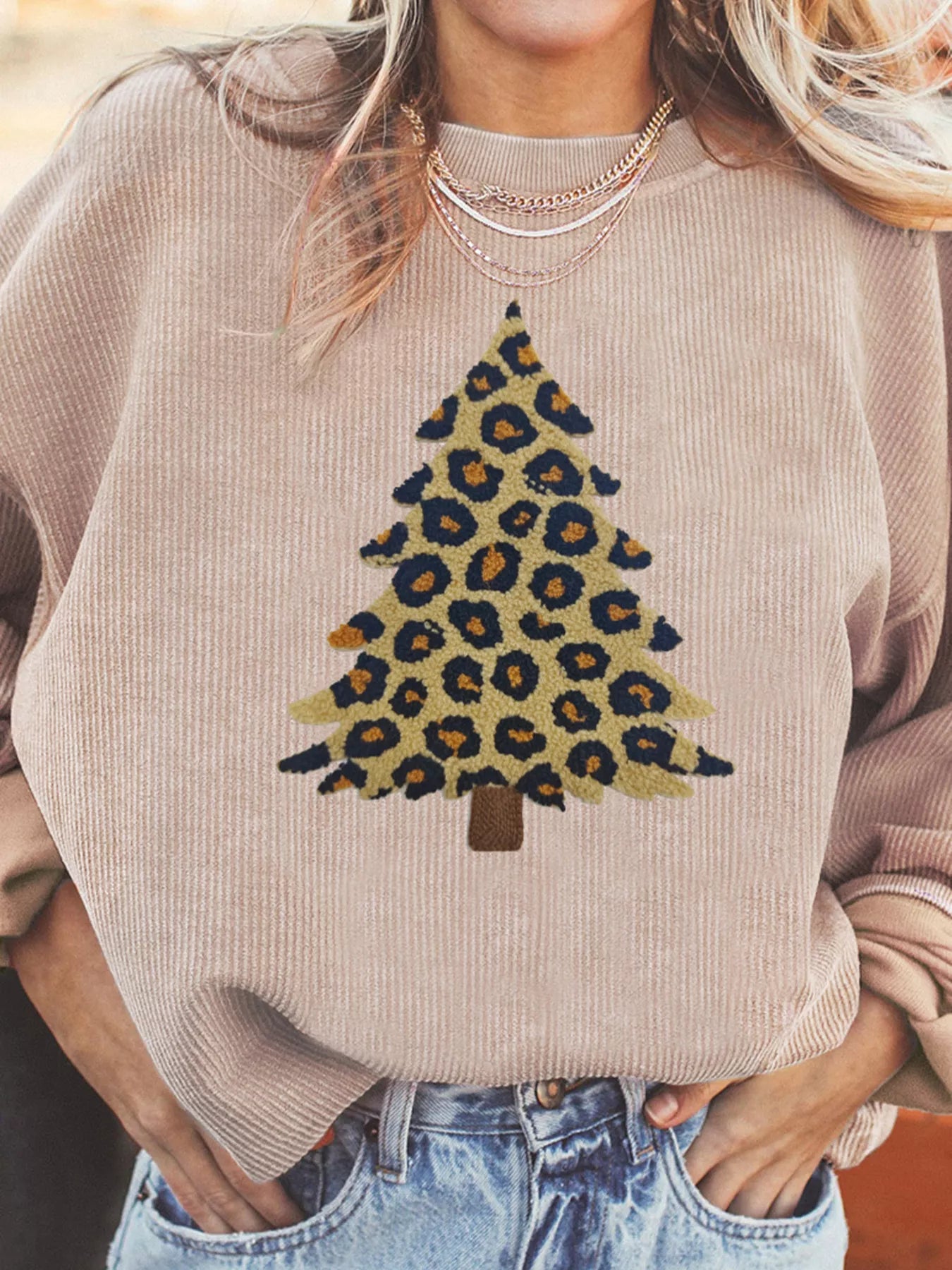Eggshell corded sweatshirt with leopard print Christmas tree graphic.