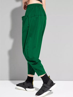 Dark green maternity harem pants with vertical texture and large front pockets.