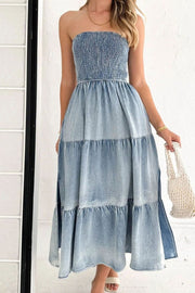 Light blue denim strapless maxi dress with smocked bodice and tiered skirt.