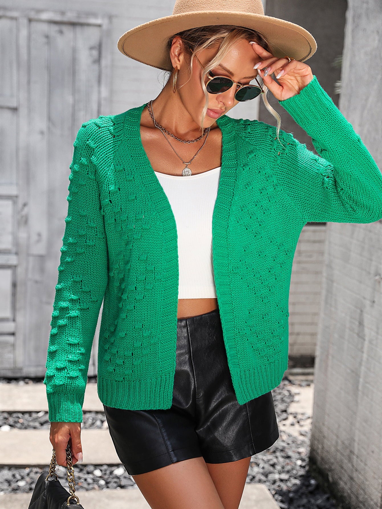 Green acrylic knit cardigan with textured sleeves and open front.