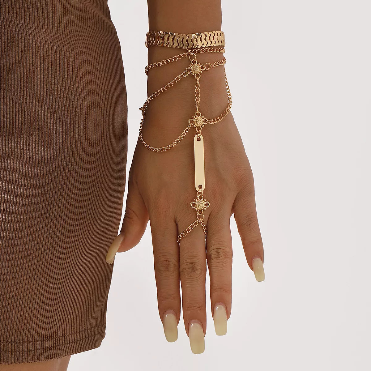 Gold multi-layered chain bracelet with bar detail and ring attachment.