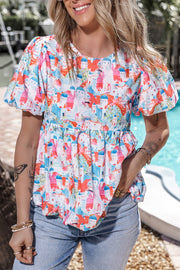 Watercolor village print peplum blouse with puff sleeves and a gathered waist.