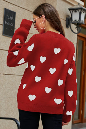 Red sweater with white heart pattern, balloon sleeves, and crew neck.