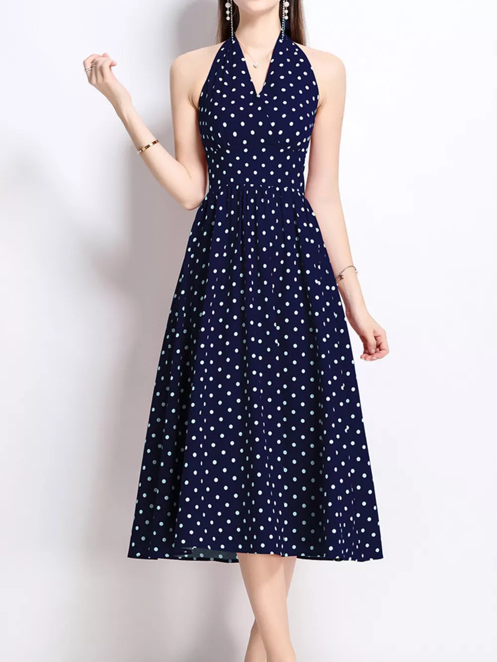 Navy polka dot halter midi dress with V-neck and flared skirt.