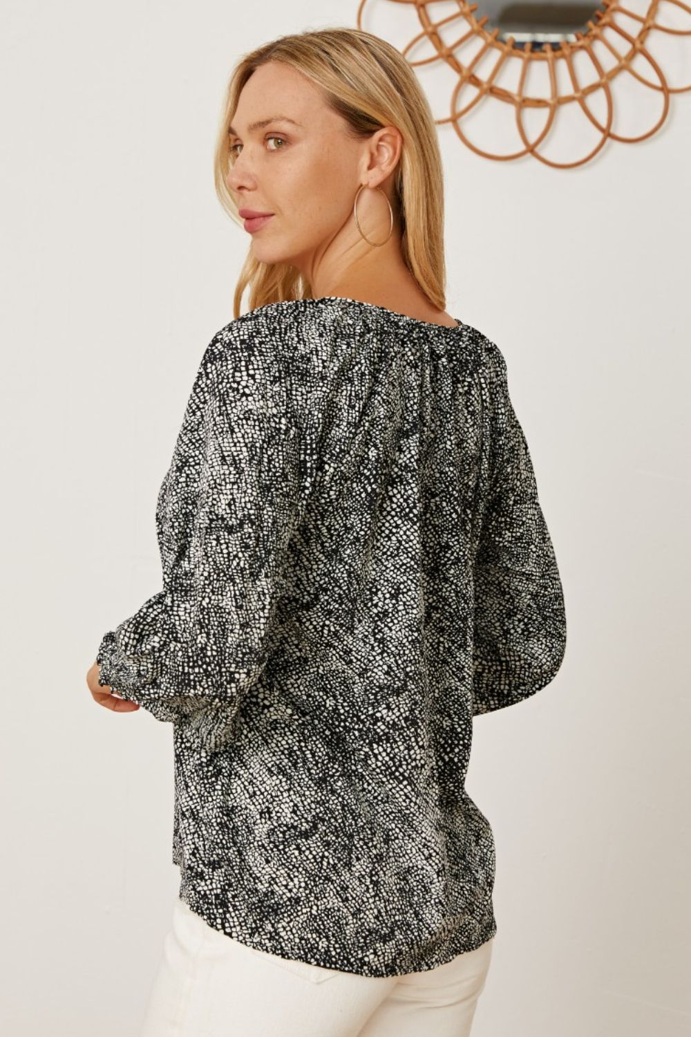Black serpentine print blouse with gathered sleeves and a relaxed fit.