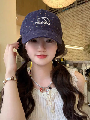 Navy blue cotton baseball cap with embroidered floral pattern and white script logo.
