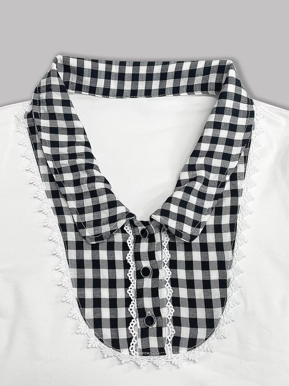 White maternity shirt with black gingham collar, lace trim, and decorative buttons.