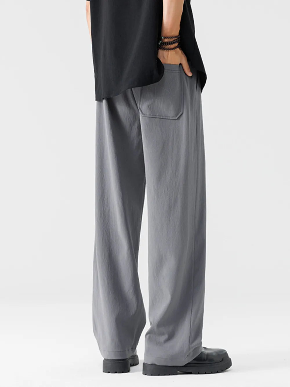 Men's light gray wide-leg sweatpants with a back pocket detail.