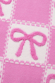 Fuchsia pink and white checkered knit sweater with textured bow details.
