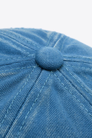 Baseball cap in blue denim with visible stitching and a button detail.