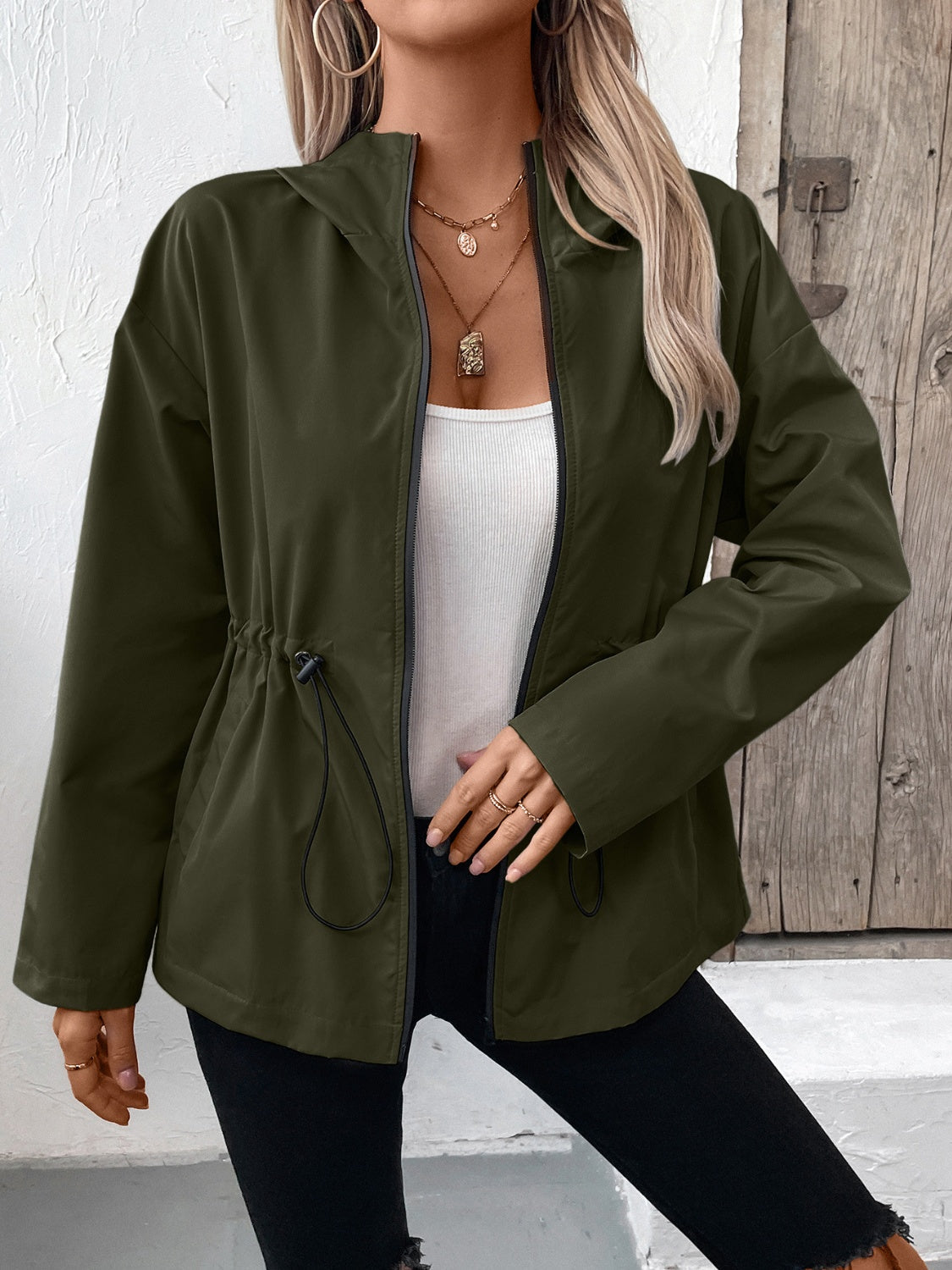 Army green utility jacket with cinched waist and drawstring detail.