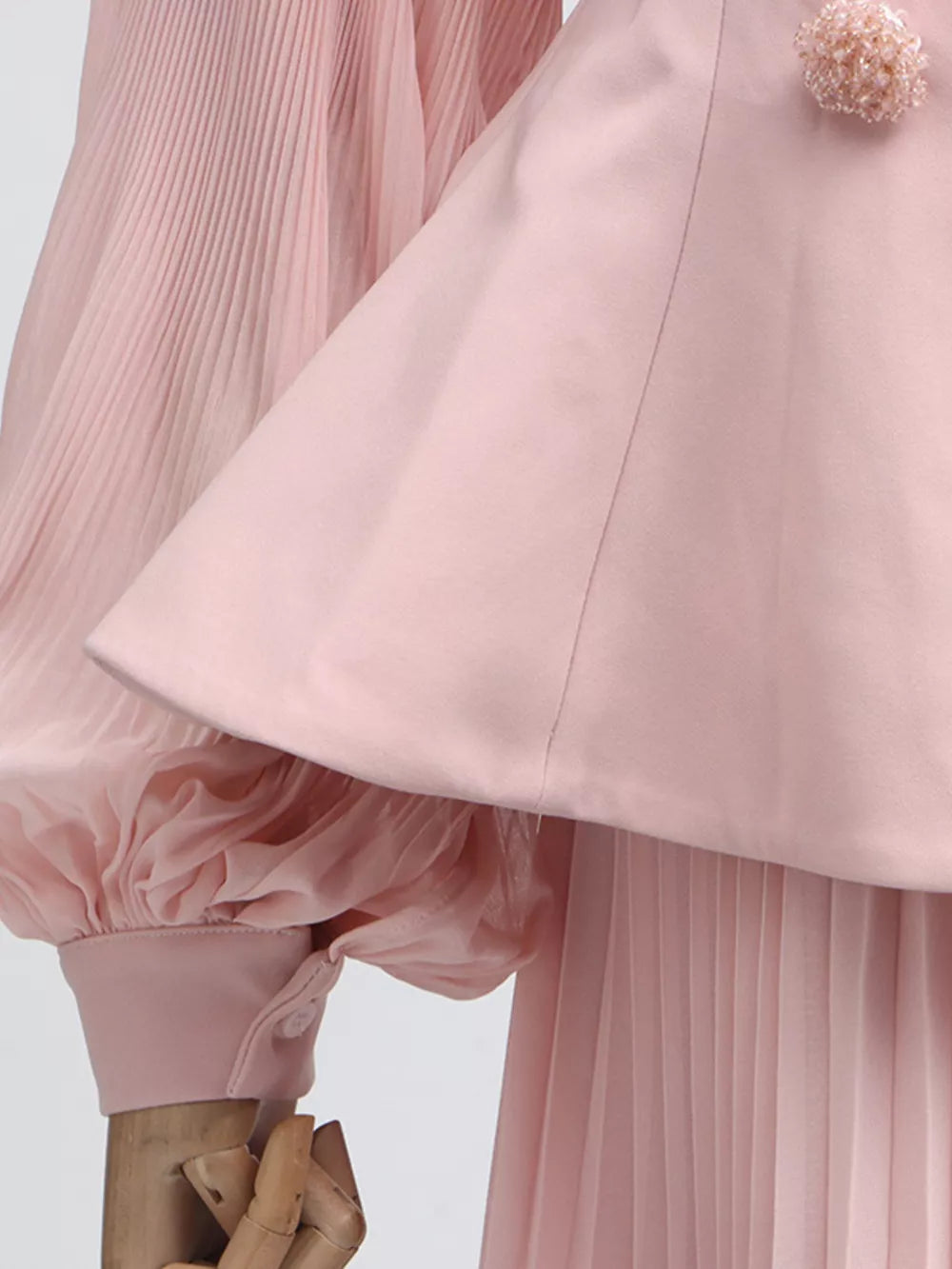 Pink skirt suit with pleated balloon sleeves and a decorative floral collar detail.
