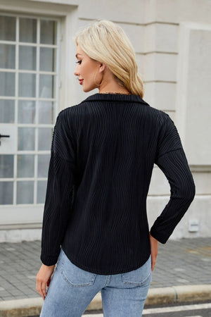 Black collared blouse with wave-effect pleating detail and long sleeves.