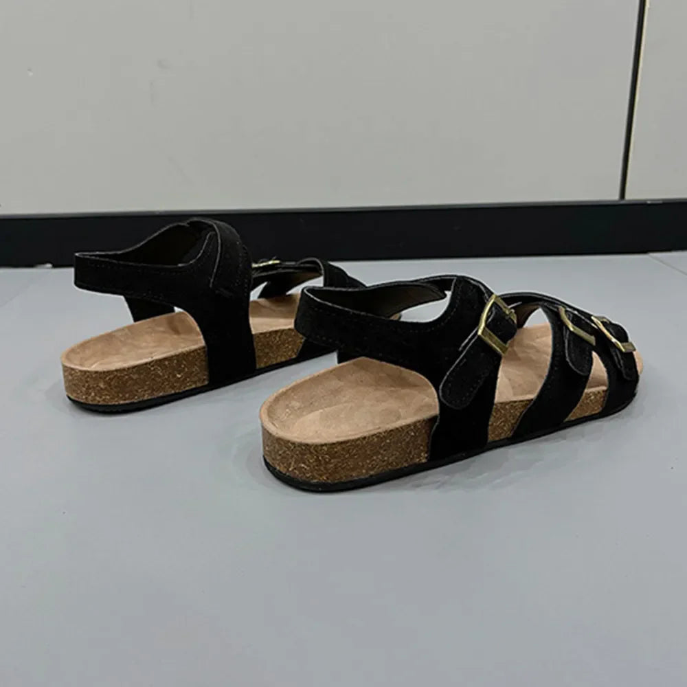 Black suede crossover buckle cork sandals with adjustable straps.