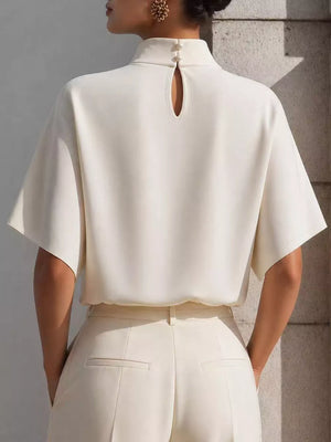 White mock neck t-shirt with relaxed sleeves and back keyhole detail.
