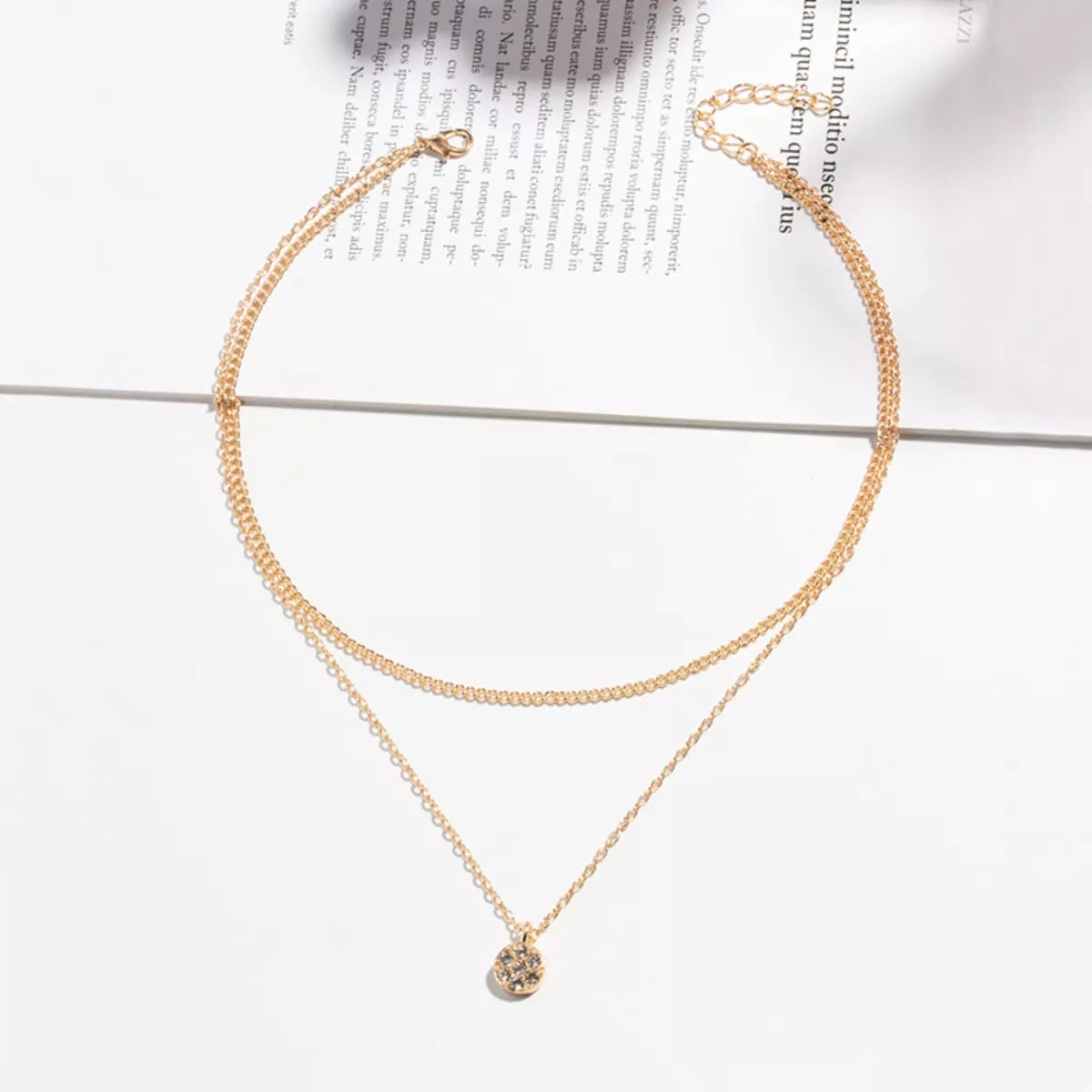 Gold double layered pendant necklace with textured disc charm