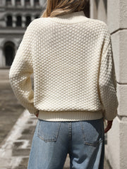 Textured mock-neck sweater in white with a basketweave knit pattern.