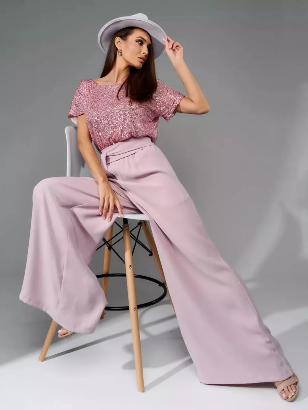 Pink sequin top with wide-leg pink pants and tie detail.