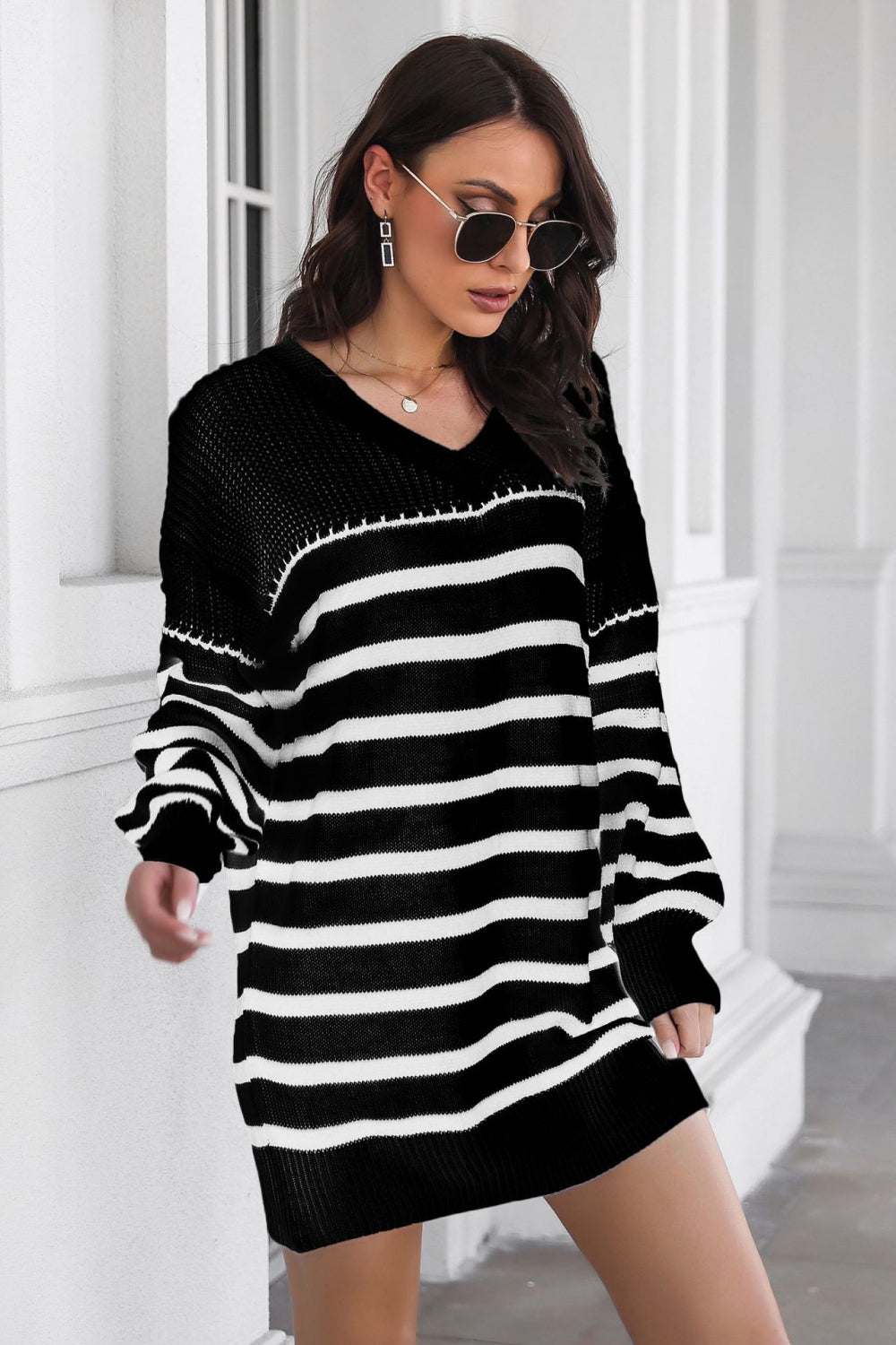 Black and white striped knit mini dress with a V-neck and long sleeves.