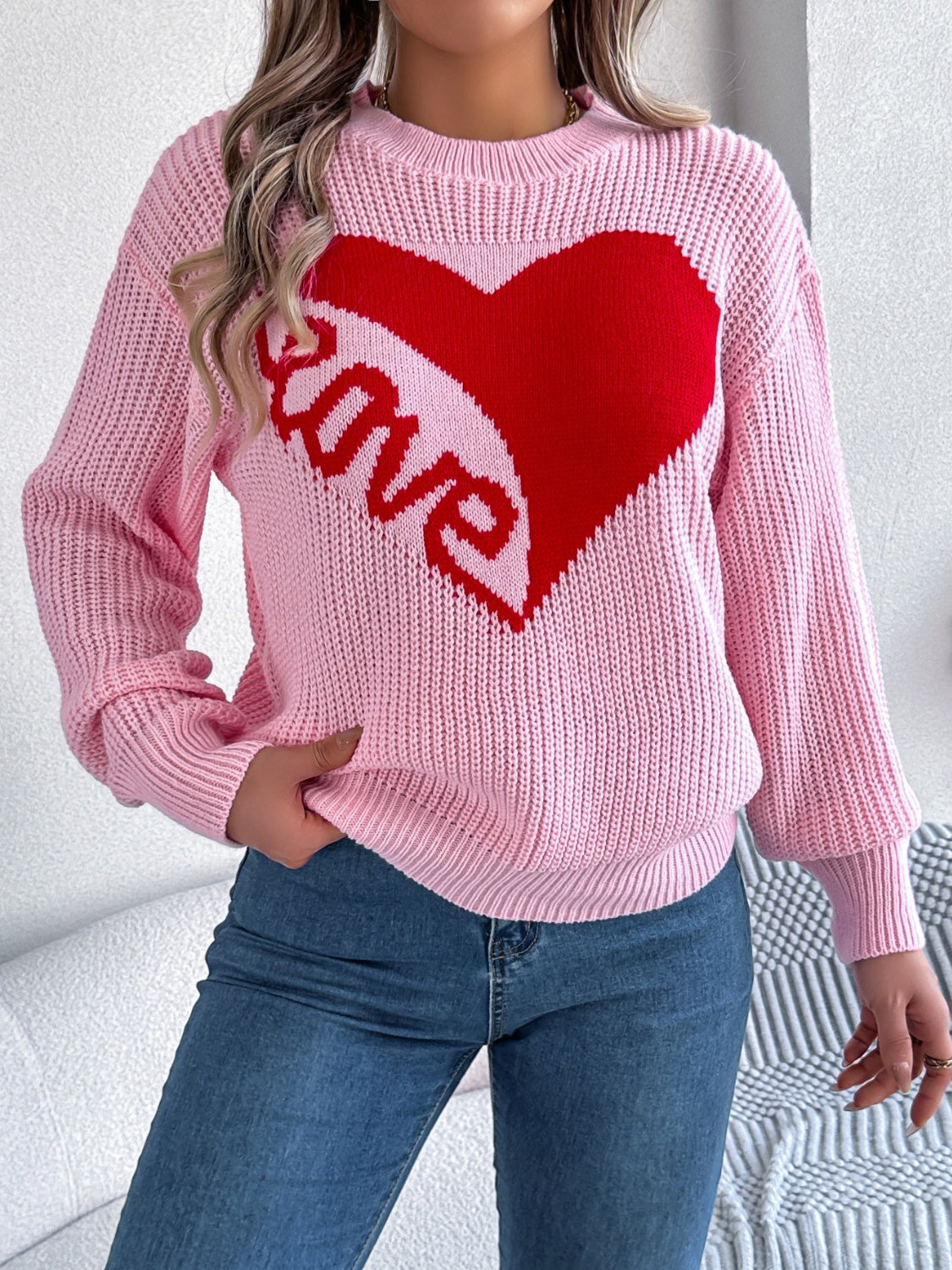 Pink knit sweater with red heart and love graphic, crew neck, long sleeves.