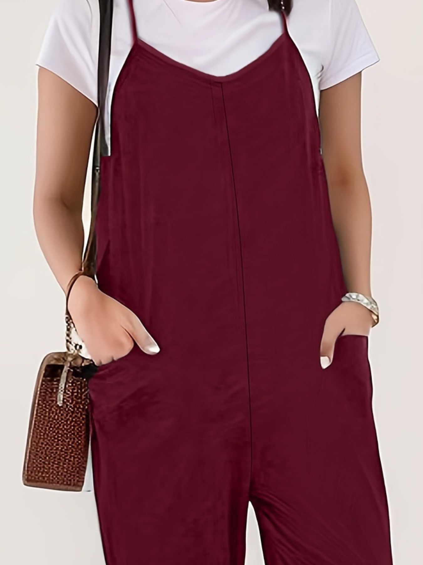 Burgundy loose fit spaghetti strap jumpsuit with pockets, styled with a white tee.