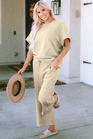 Beige textured knit tee and wide leg pants set with drawstring waist and pockets.