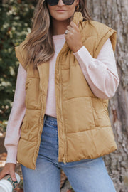 Padded tan sleeveless hooded vest with zipper and pockets, worn over a pink sweater.