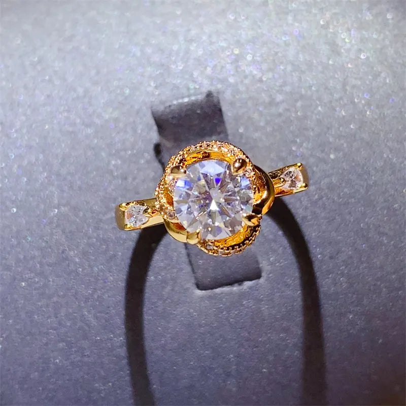 Gold halo ring with moissanite center stone and floral design.