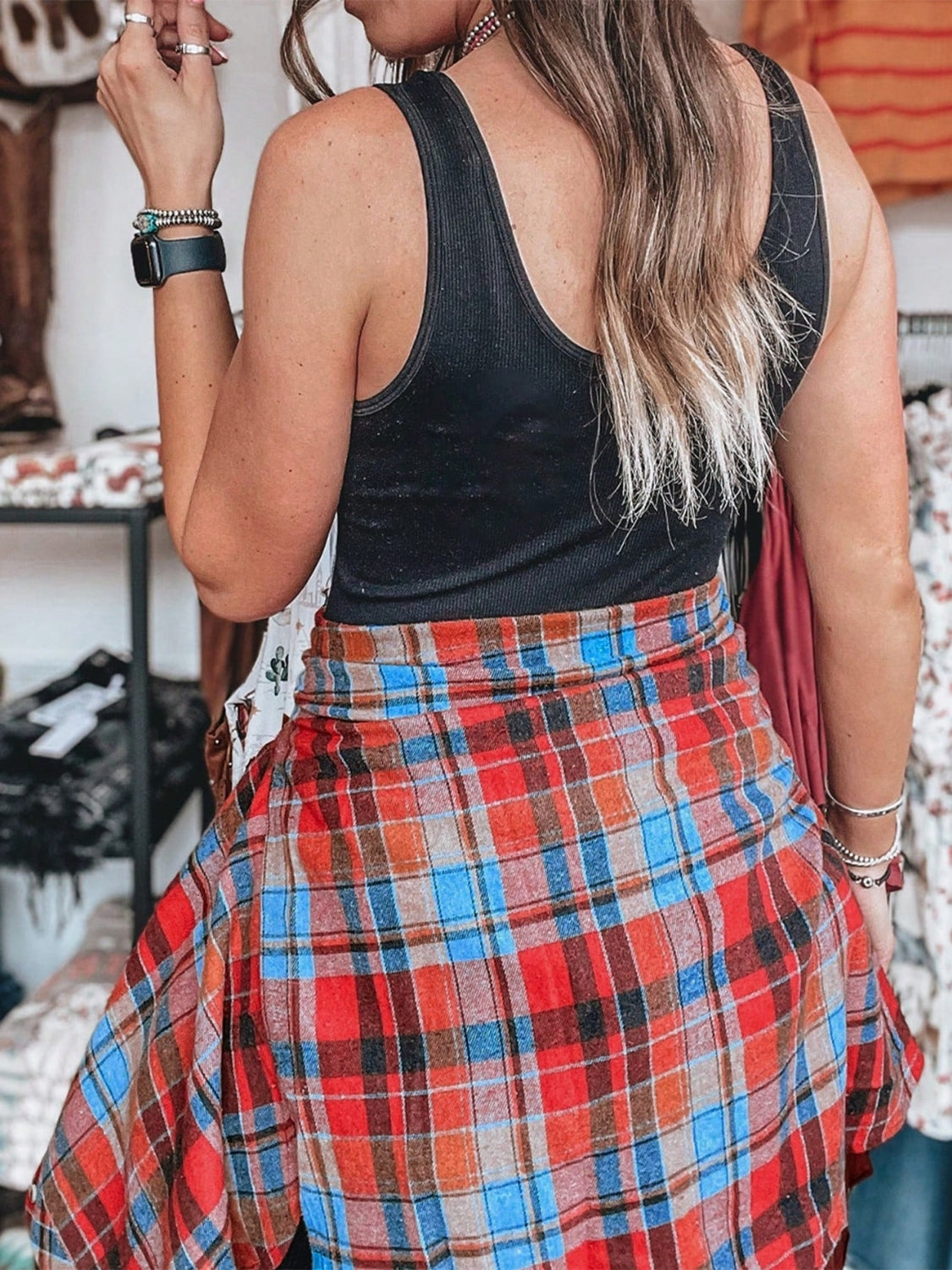 Oversized plaid shacket in red, blue, and orange with a relaxed fit, styled open over a black tank top.