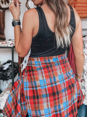 Oversized plaid shacket in red, blue, and orange with a relaxed fit, styled open over a black tank top.