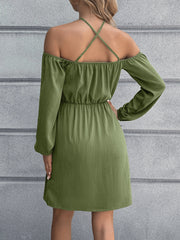 Matcha green off-shoulder mini dress with long sleeves and crisscross back straps.