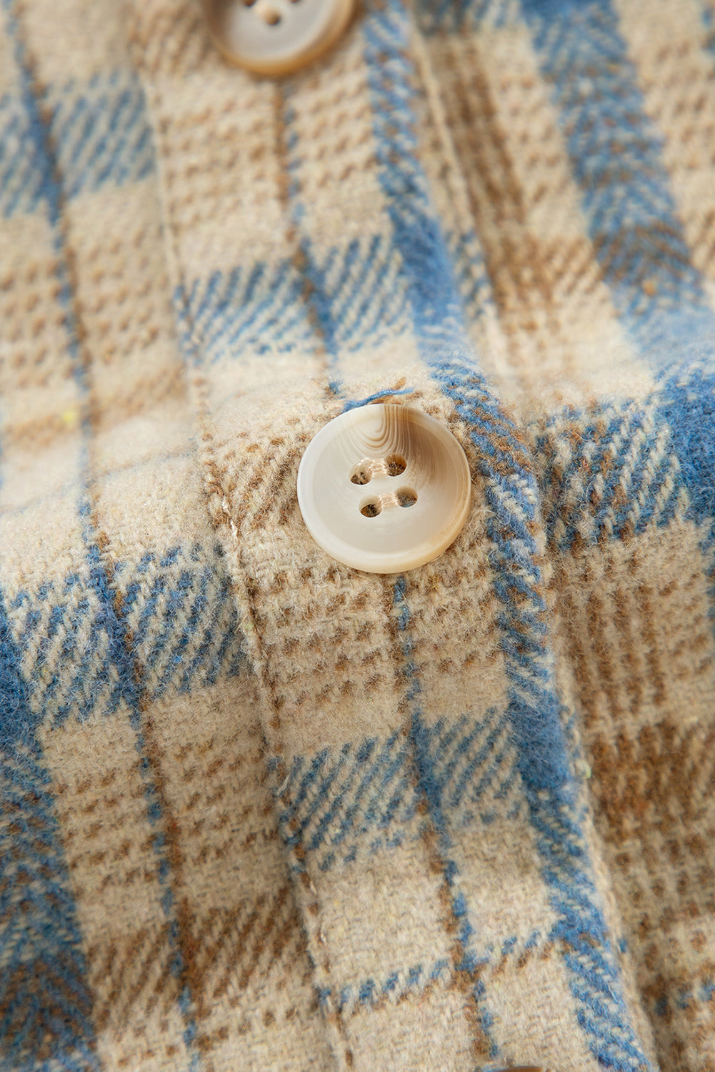Textured plaid hooded overshirt with raw hem and button detail.