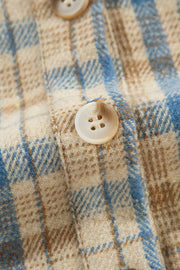 Textured plaid hooded overshirt with raw hem and button detail.