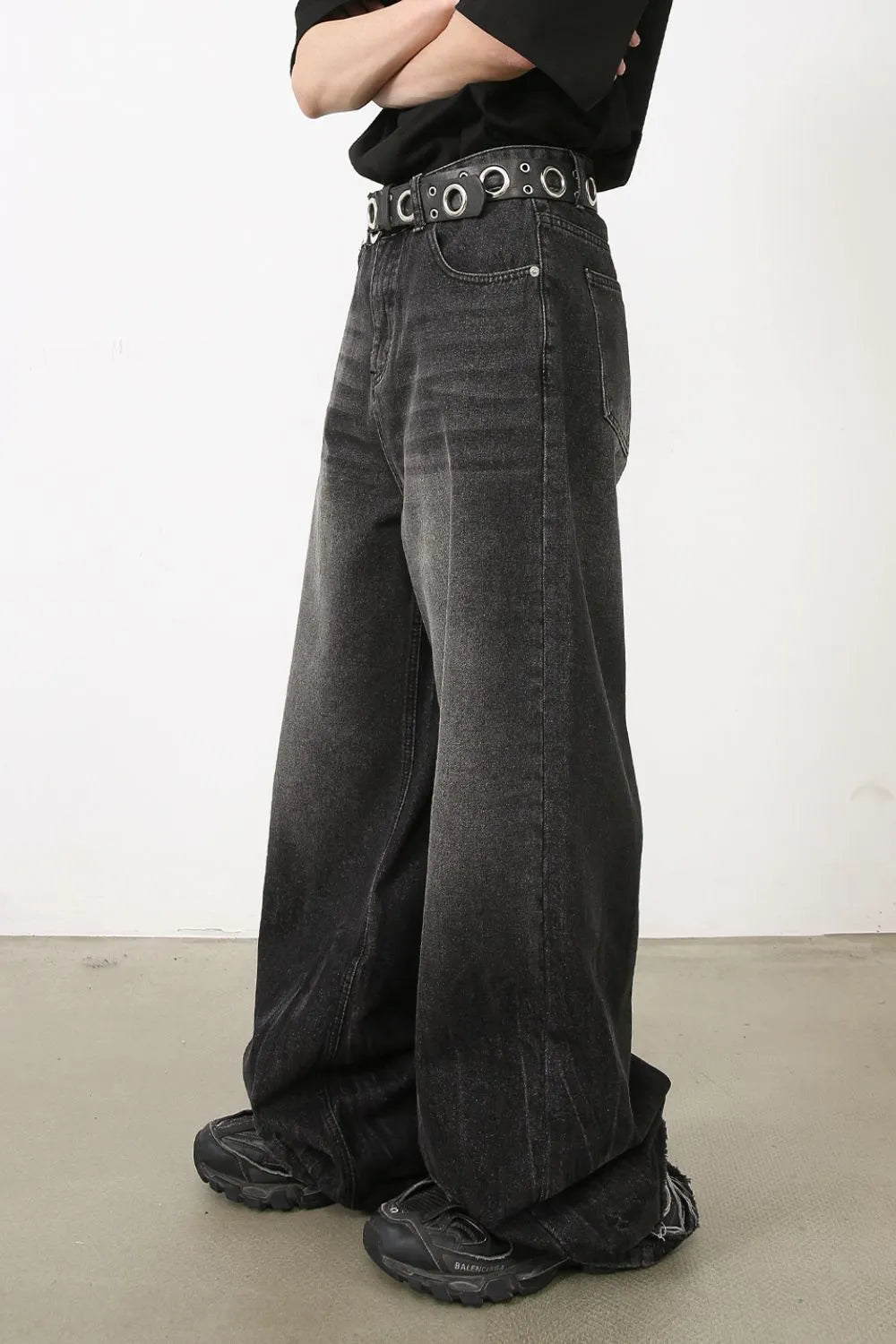 Dark balloon-leg denim jeans with subtle fade and a grommet belt.