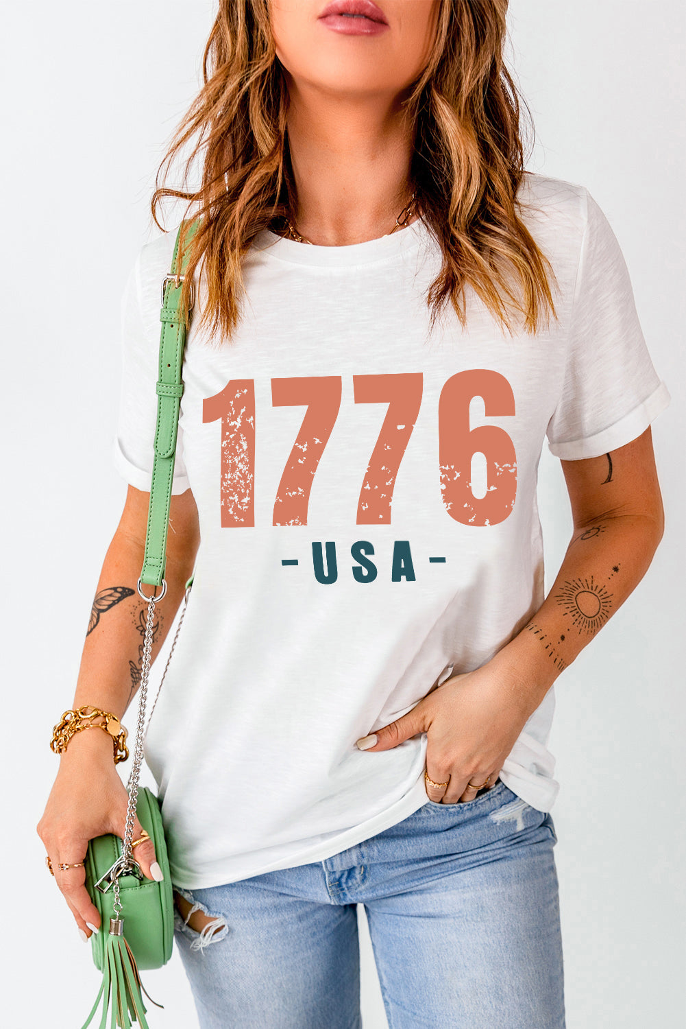 White graphic tee with distressed 1776 USA print and short sleeves.