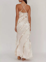 Beige spaghetti strap maxi dress with diagonal ruffles and criss-cross back straps.