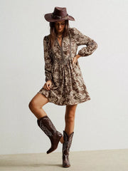 Brown floral print dress with notched neckline and long sleeves, detailed with lace trim.