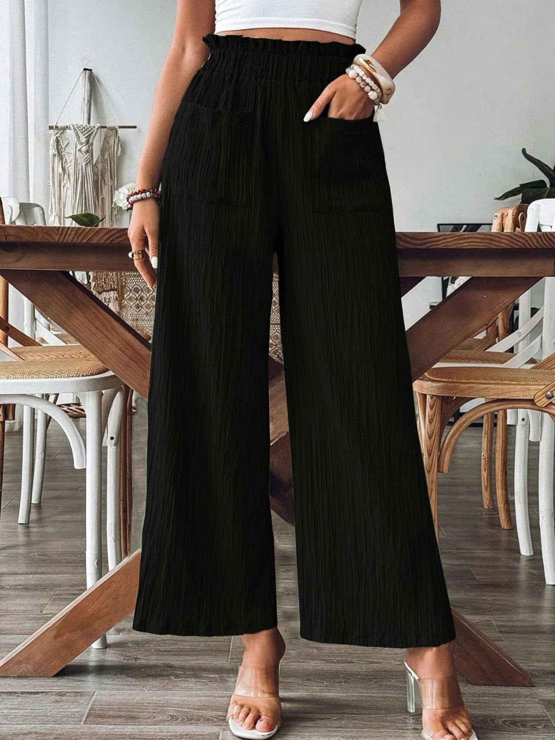 Black textured gauze palazzo trousers with elastic waist and pockets.
