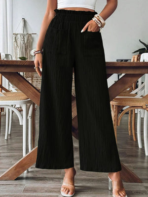 Black textured gauze palazzo trousers with elastic waist and pockets.