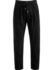 Black pleated linen drawstring trousers with a relaxed fit.