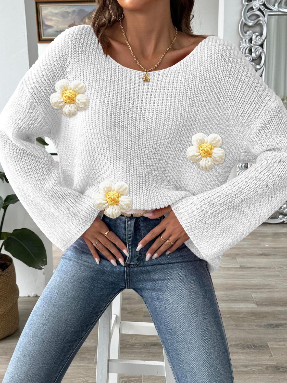 White knit sweater with floral appliqués and a slouchy fit.