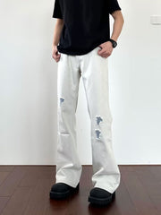 Men's light wash distressed wide-leg jeans with ripped details.
