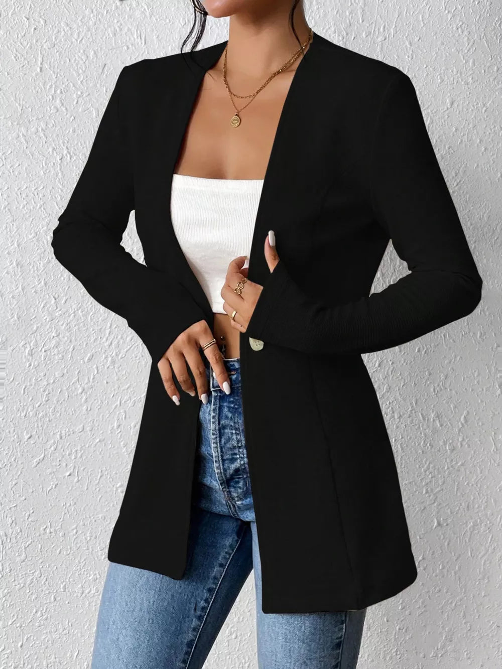 Black single-button blazer with tailored fit and open front, styled with jeans.