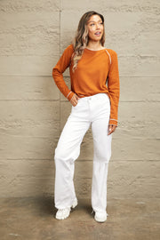 Caramel waffle knit raglan sweater with contrast stitching and ruffled cuffs.