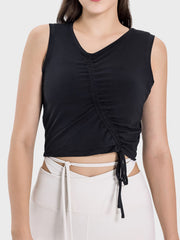 Black asymmetric ruched crop tank top with V-neck and adjustable drawstring detail.