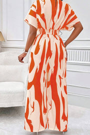Orange abstract brushstroke wide-leg jumpsuit with short sleeves and elastic waist