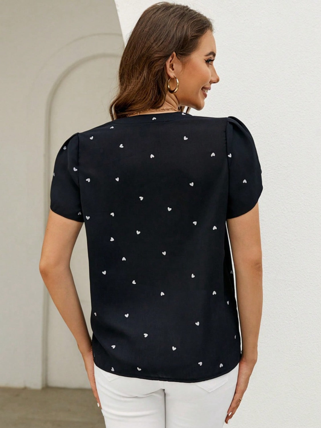Black heart print puff sleeve blouse with a V-neckline.