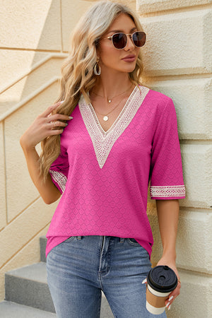 Hot pink textured v-neck blouse with lace trim details and short sleeves.