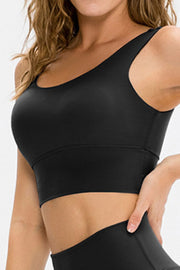 Seamless black scoop neck crop top with a wide band and racerback detail.